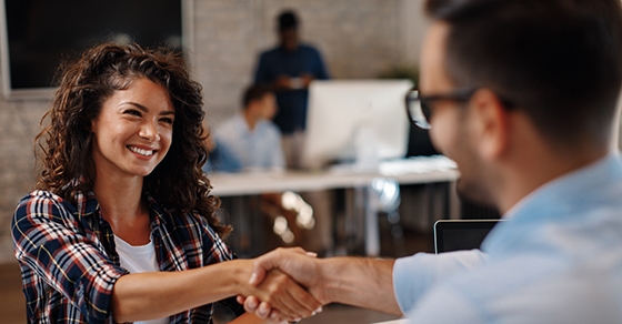 Young woman signing contracts and handshake with a manager