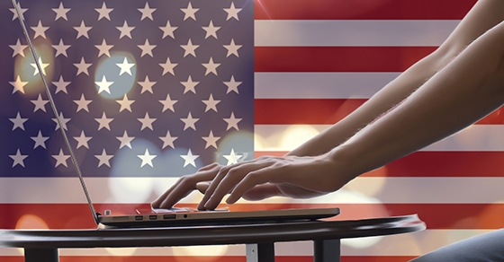 woman's hands using laptop with blank screen on table in offie. american flag light night bokeh abstract background. Usa flag