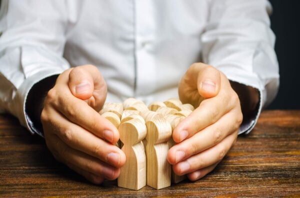 hands around wooden people