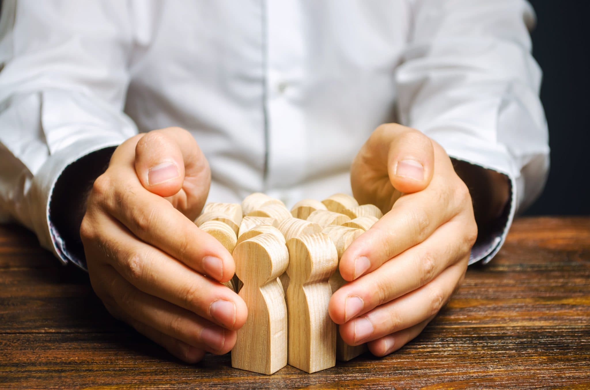 hands around wooden people