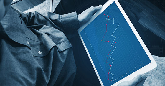 a man working on digital tablet, business decreasing graph on screen