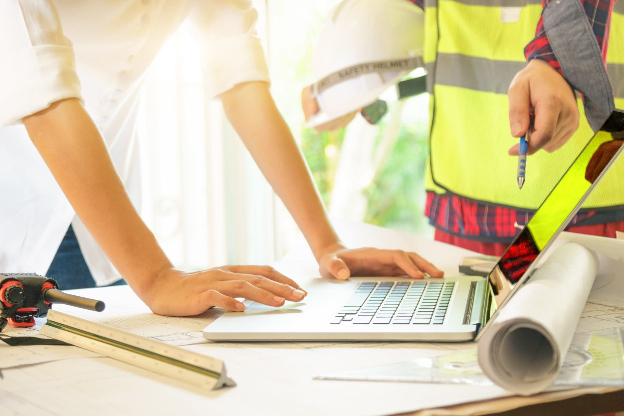 engineer and employee looking at laptop