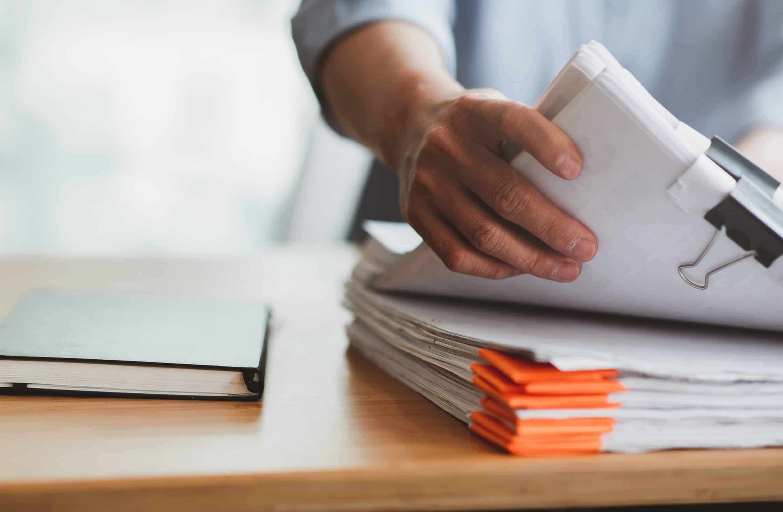 hand holding pile of documents