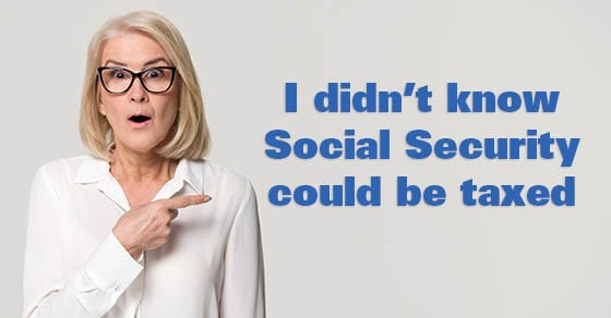 Surprised mature businesswoman pointing finger at copyspace isolated on background