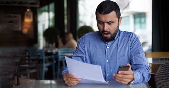 surprised man looking at documents