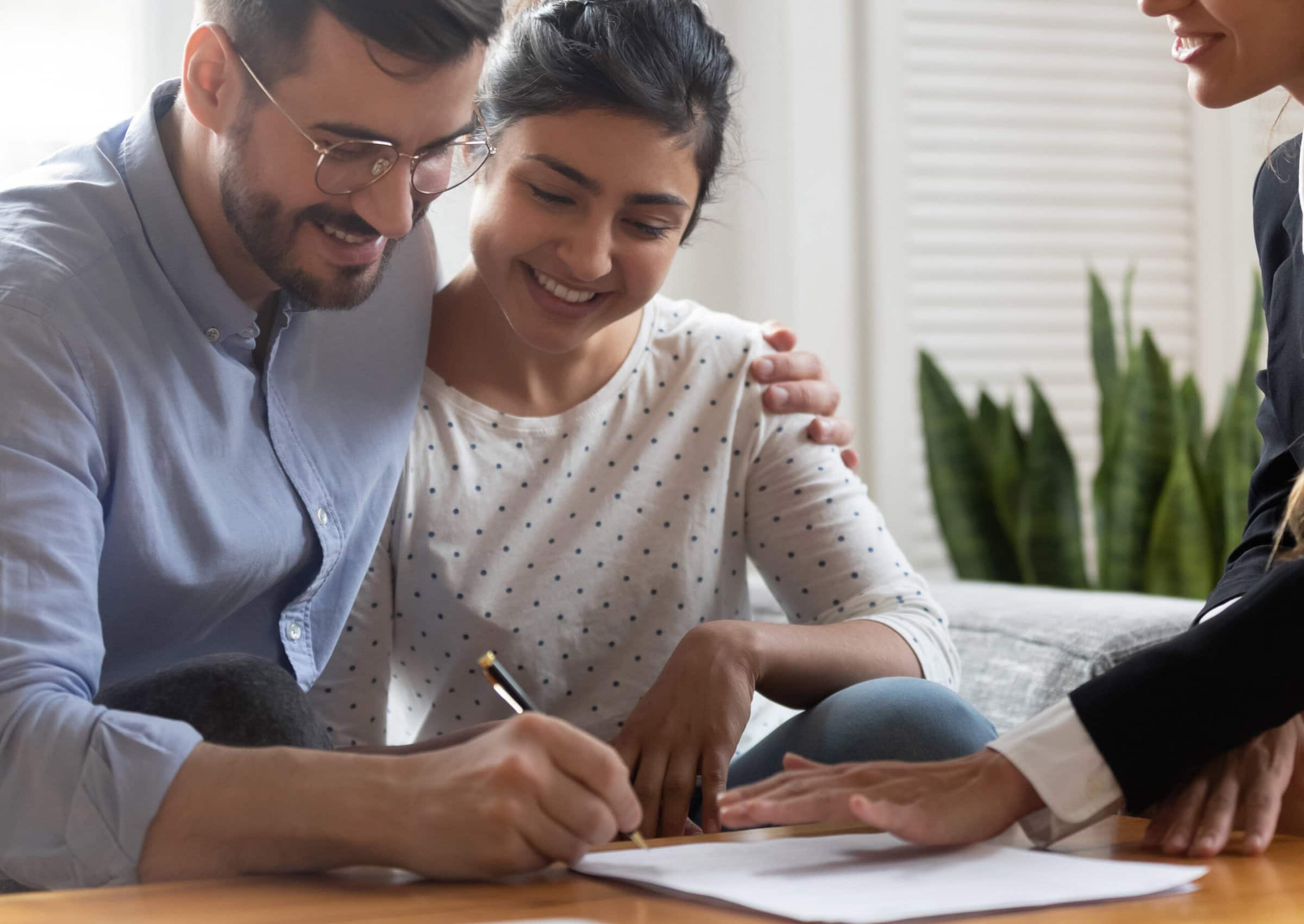 Horizontal,View,Happy,Married,Couple,Caucasian,Husband,Indian,Ethnicity,Wife Happy married couple signing a document