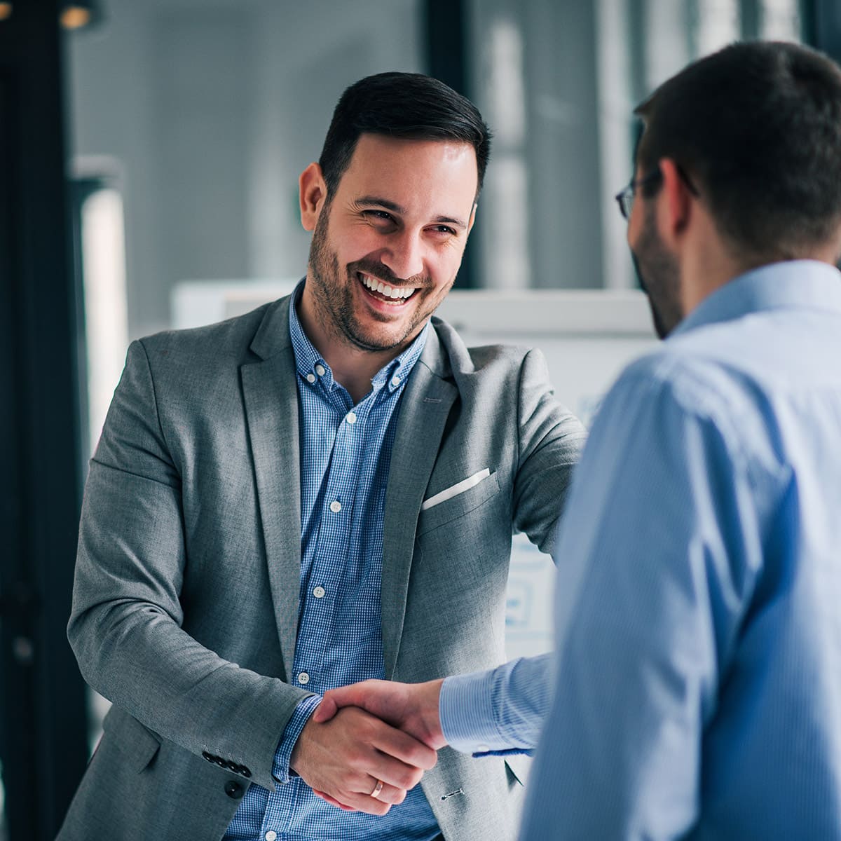 two men in business clothing shaking hands