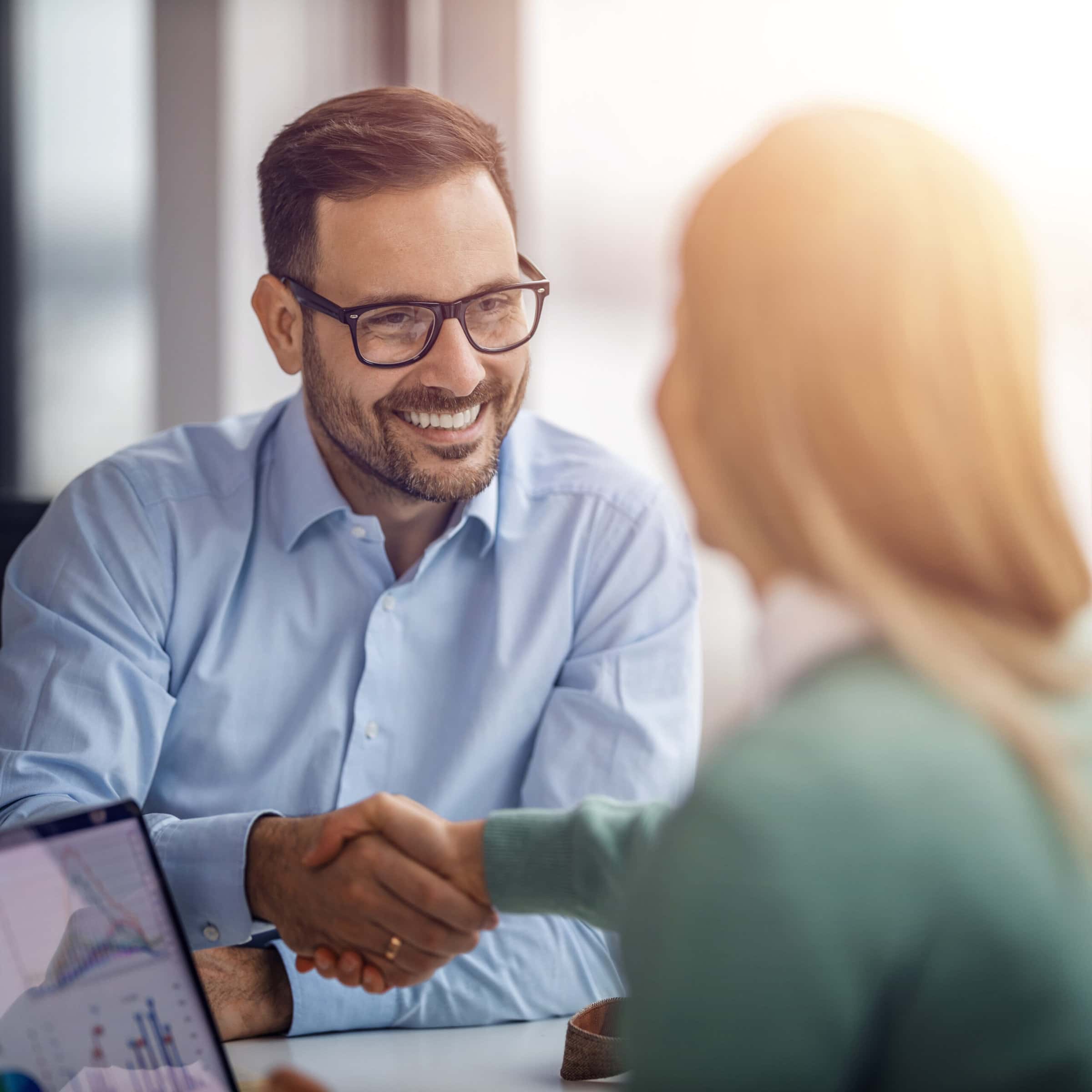 happy businessman shaking hands with client