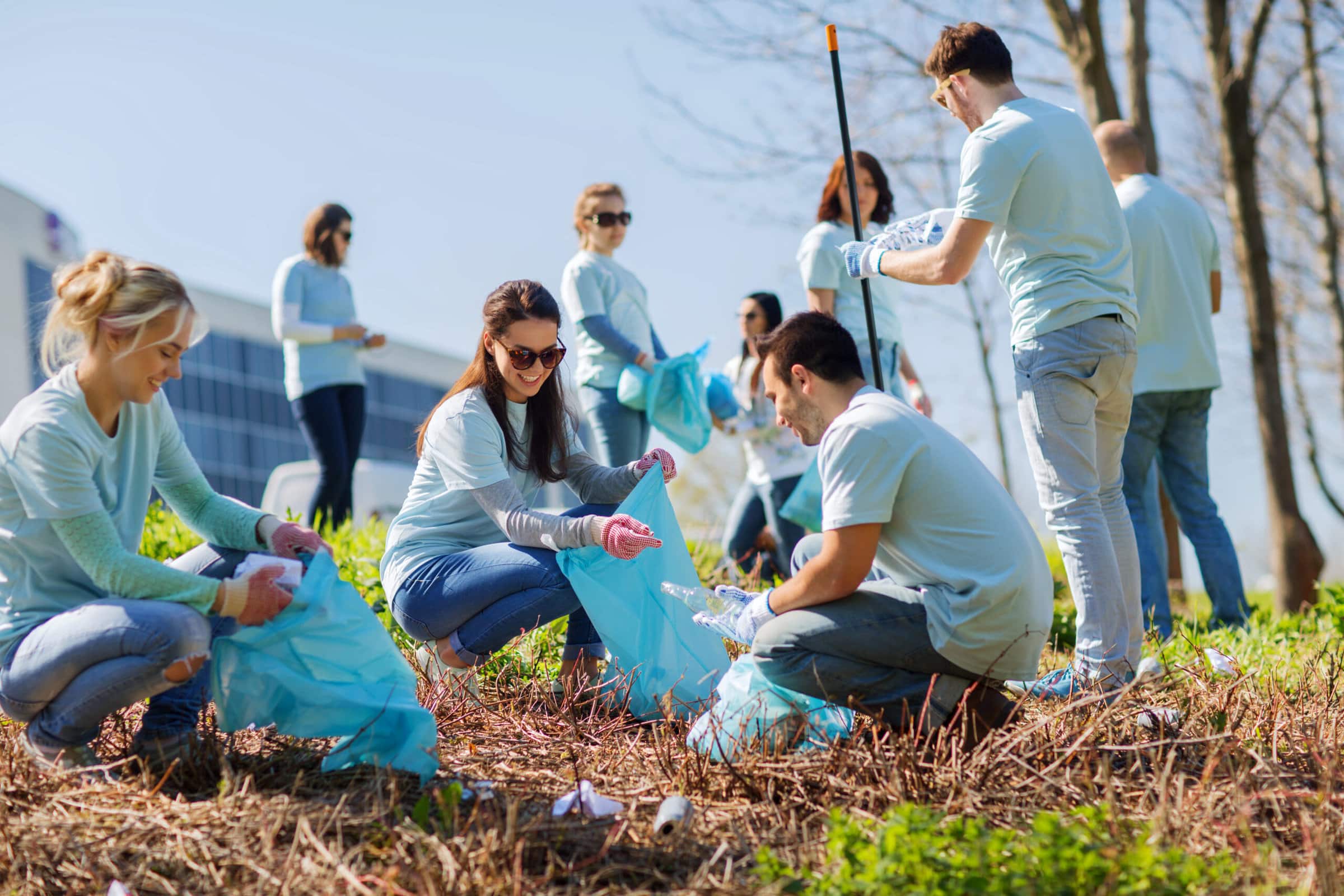 volunteers with garbage bags cleaning park area