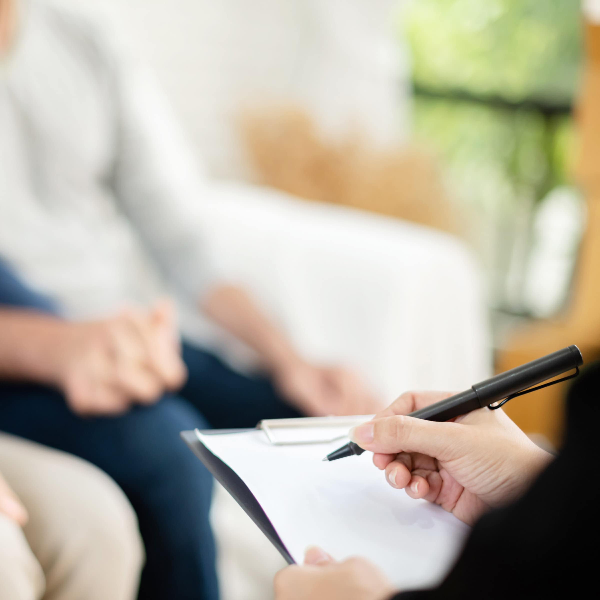 closeup photo of a woman's hand writing on paper while discussing with customers