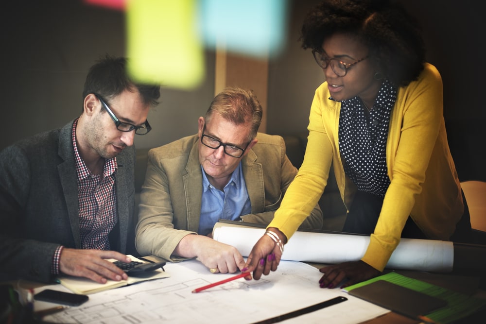 Three people discussing architecture plans