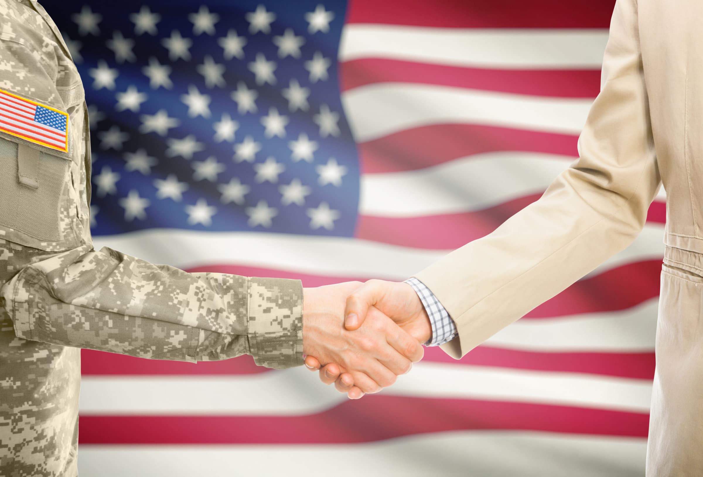 USA military man in uniform and civil man in suit shaking hands