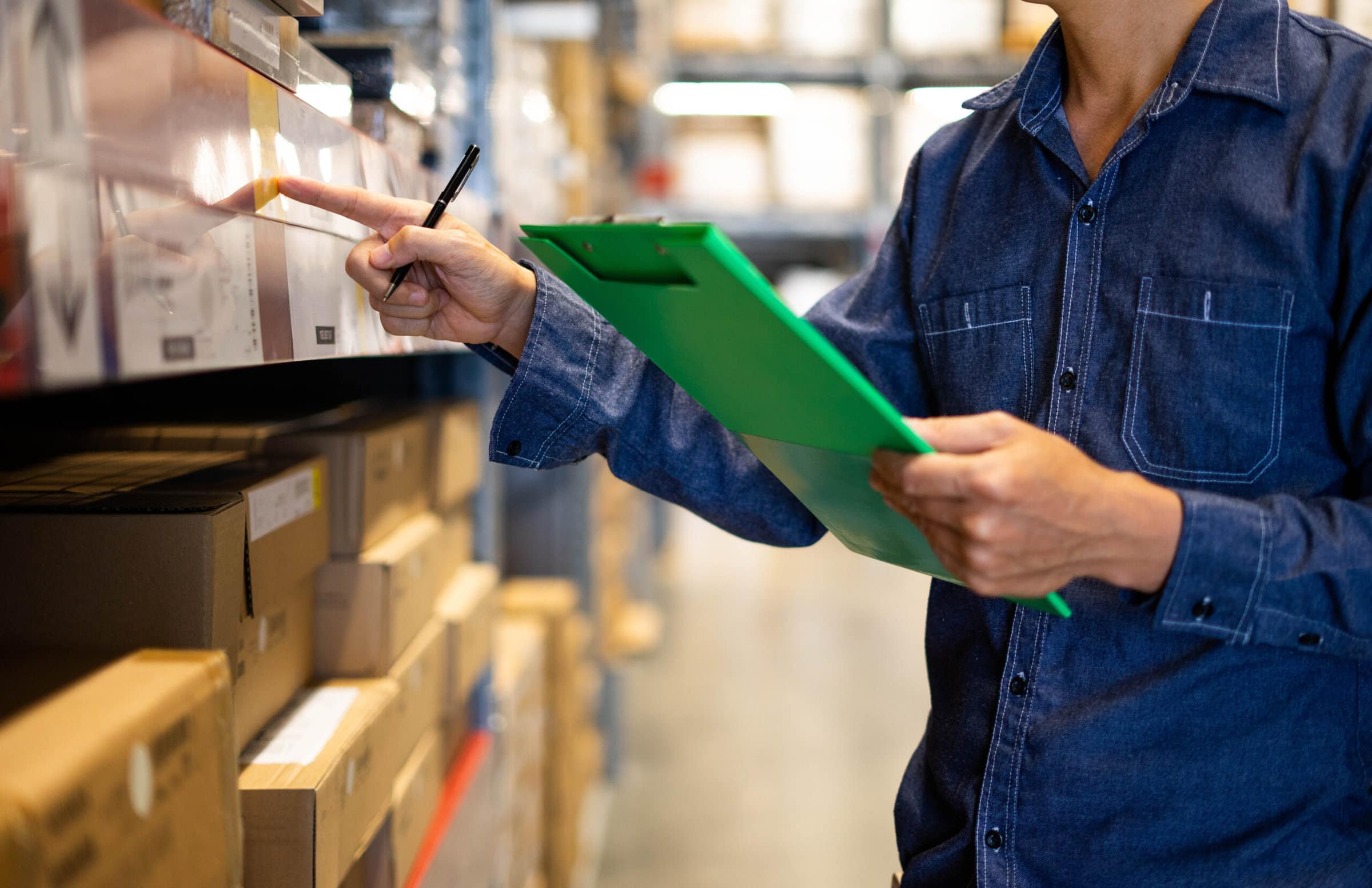 Manager man worker doing stocktaking of product management in cardboard box on shelves in warehouse. Physical inventory count.
 Male professional assistant checking stock in factory.