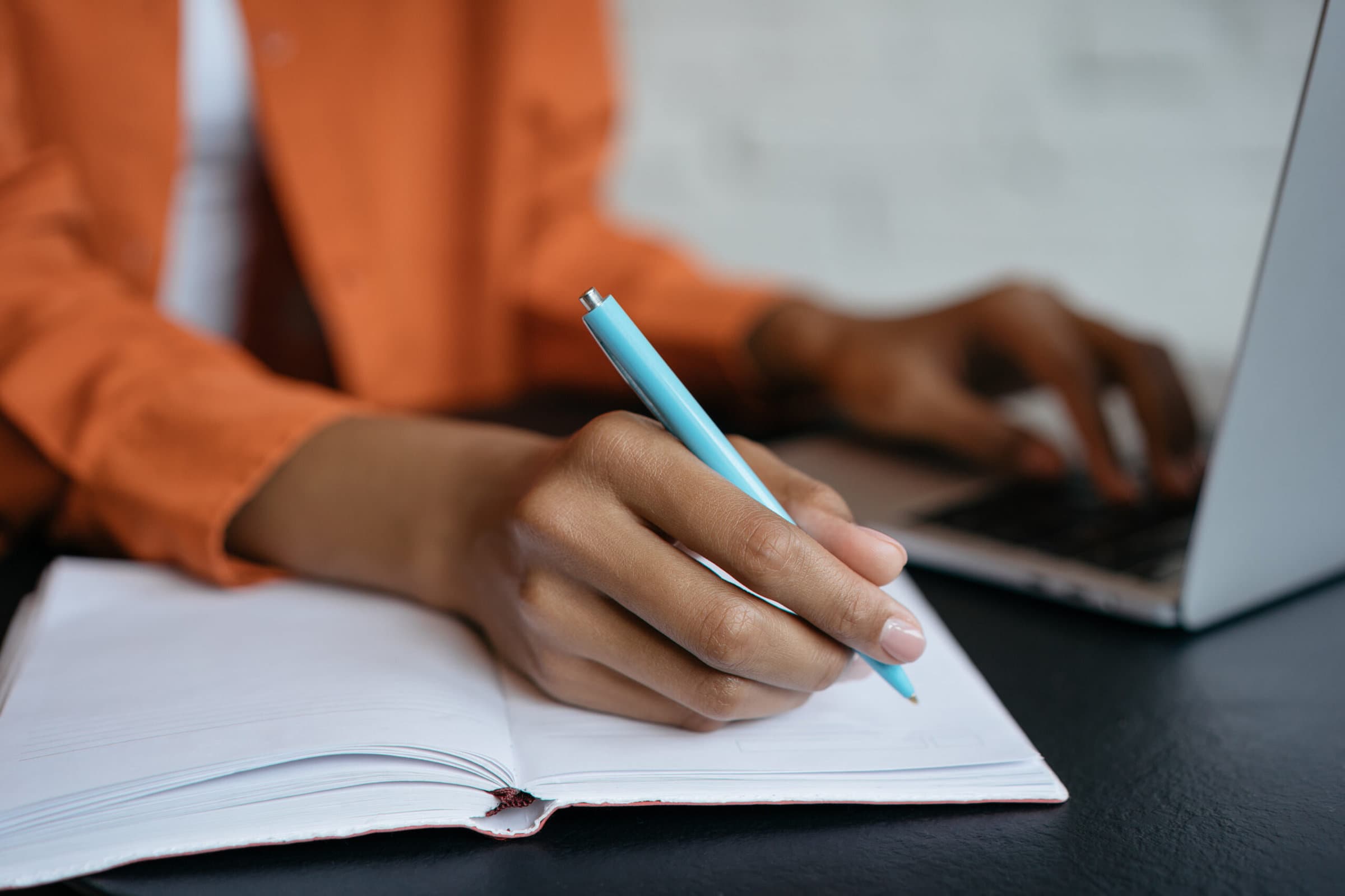 Closeup shot of university student hand using pen and writing in