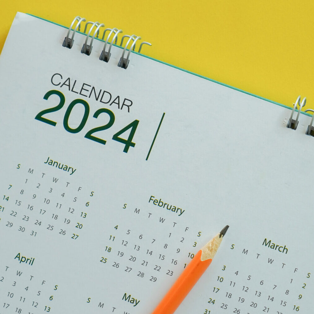 close up top view on white calendar 2024 with schedule of month and pencil to write or note and mark on important date for lifestyle and new year resolution concept