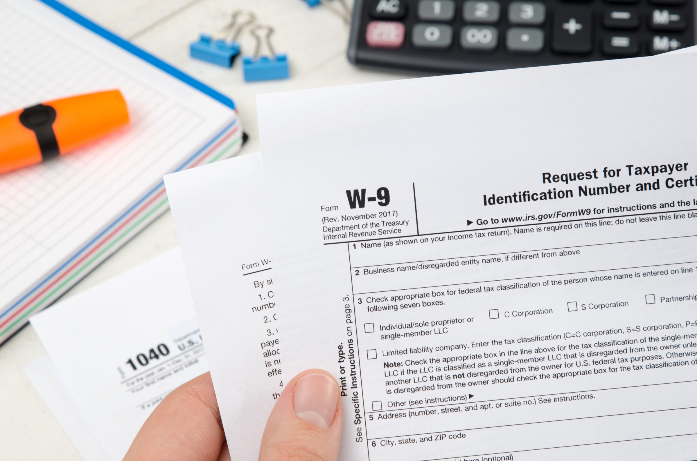 Man holding US tax form W-9. Tax form law document irs business concept