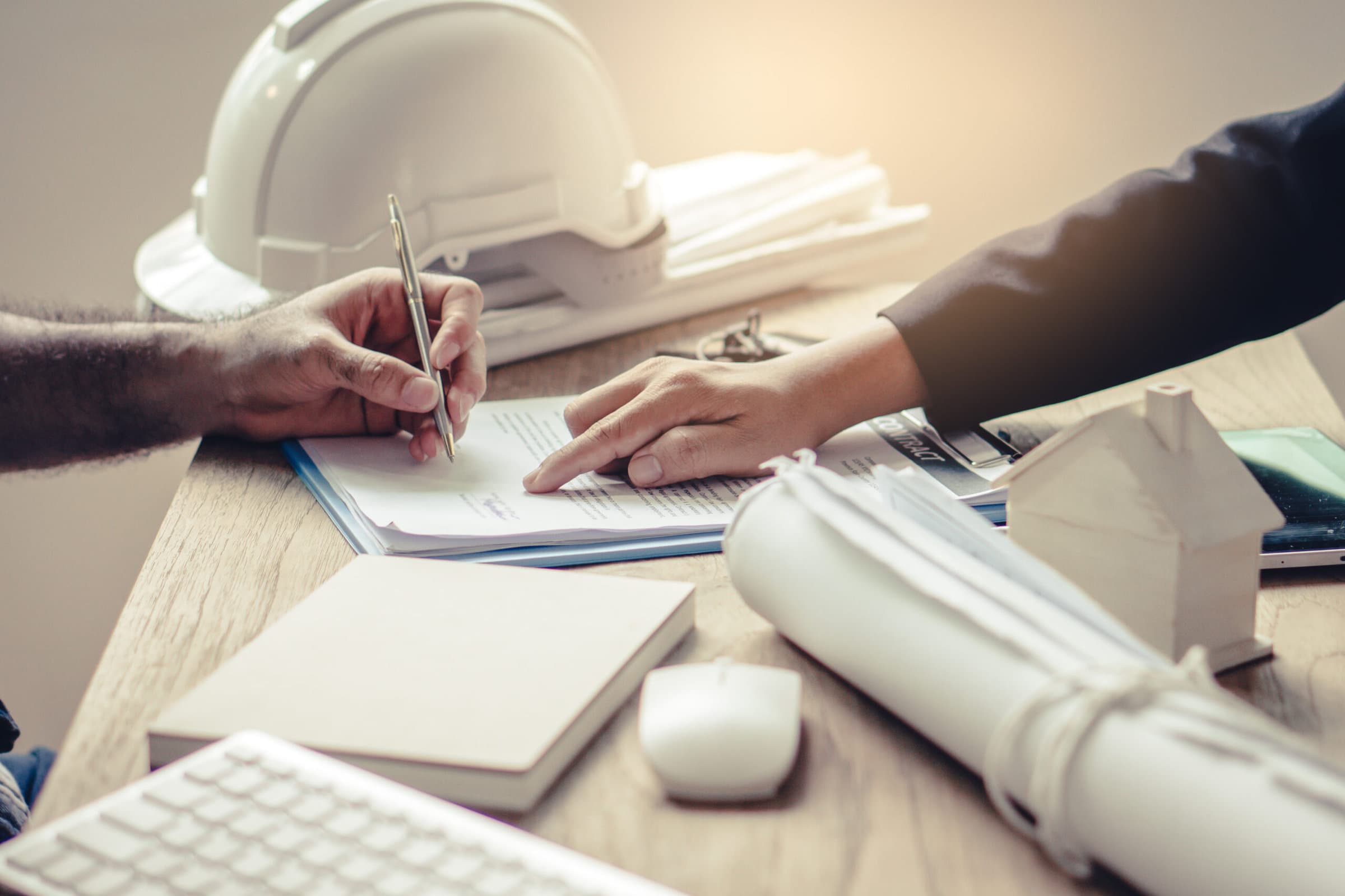 Business partners contract agreement success. Top view of close up hand of bank broker showing to client where to sign signature in contract for housing loan. Document in picture is fake.