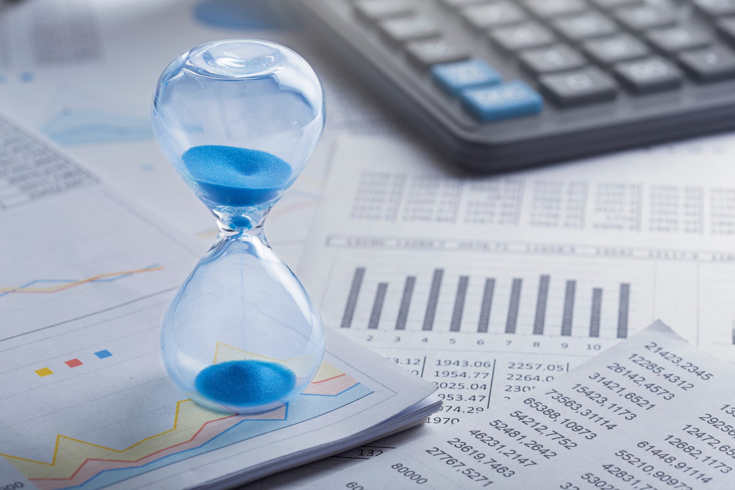 Best time for investment. Hourglass, financial charts and calculator.