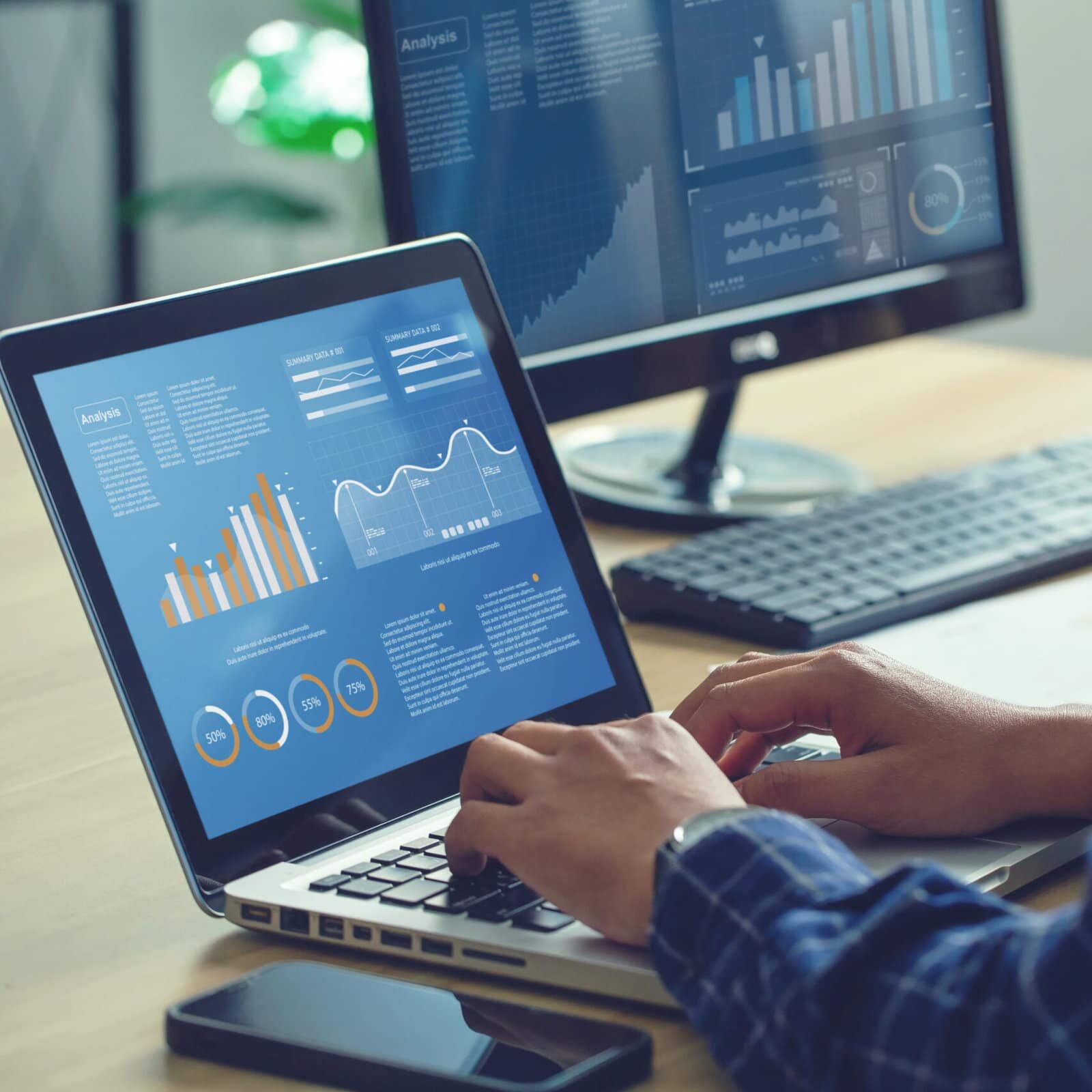 Analyst Works on Personal Computer Showing business analytics dashboard with charts, metrics and KPI to analyze performance and create insight reports for operations management. Data analysis concept.