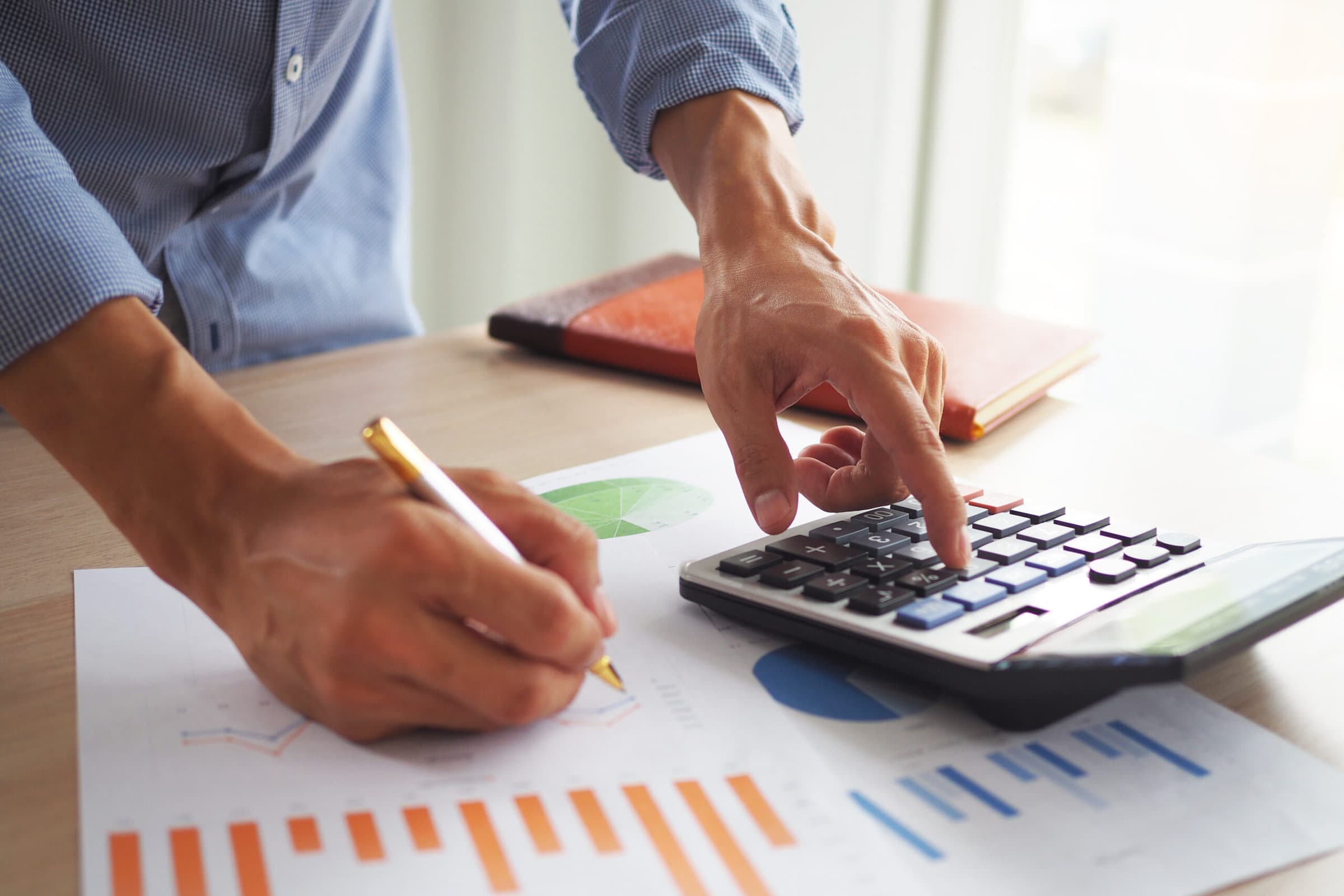 Men business men are calculating their income. Use the calculator and view the data graph. Analytical thinking concept