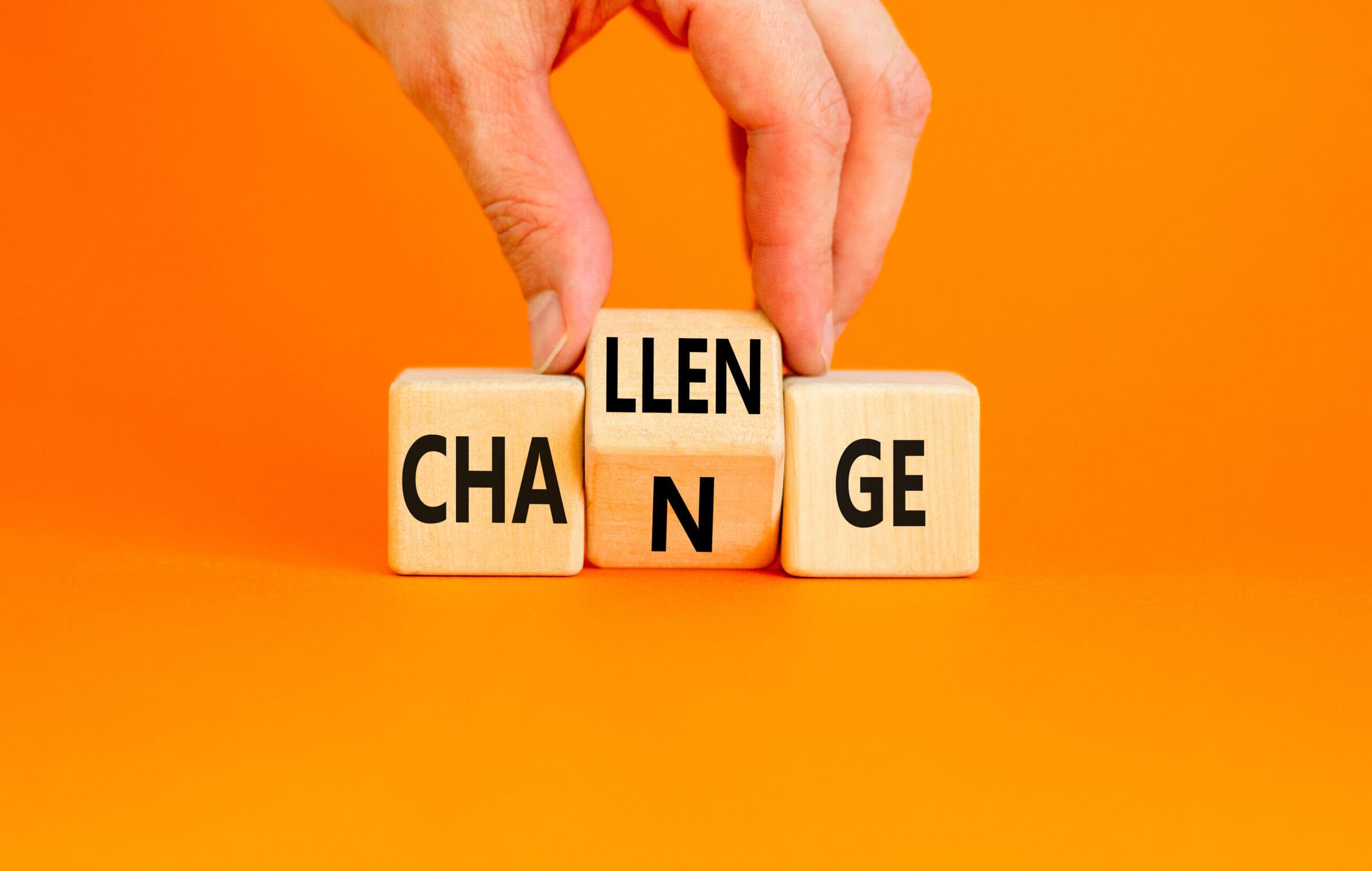 Challenge and change symbol. Concept word Challenge Change on wooden cubes. Businessman hand. Beautiful orange table orange background. Business and challenge and change concept. Copy space.