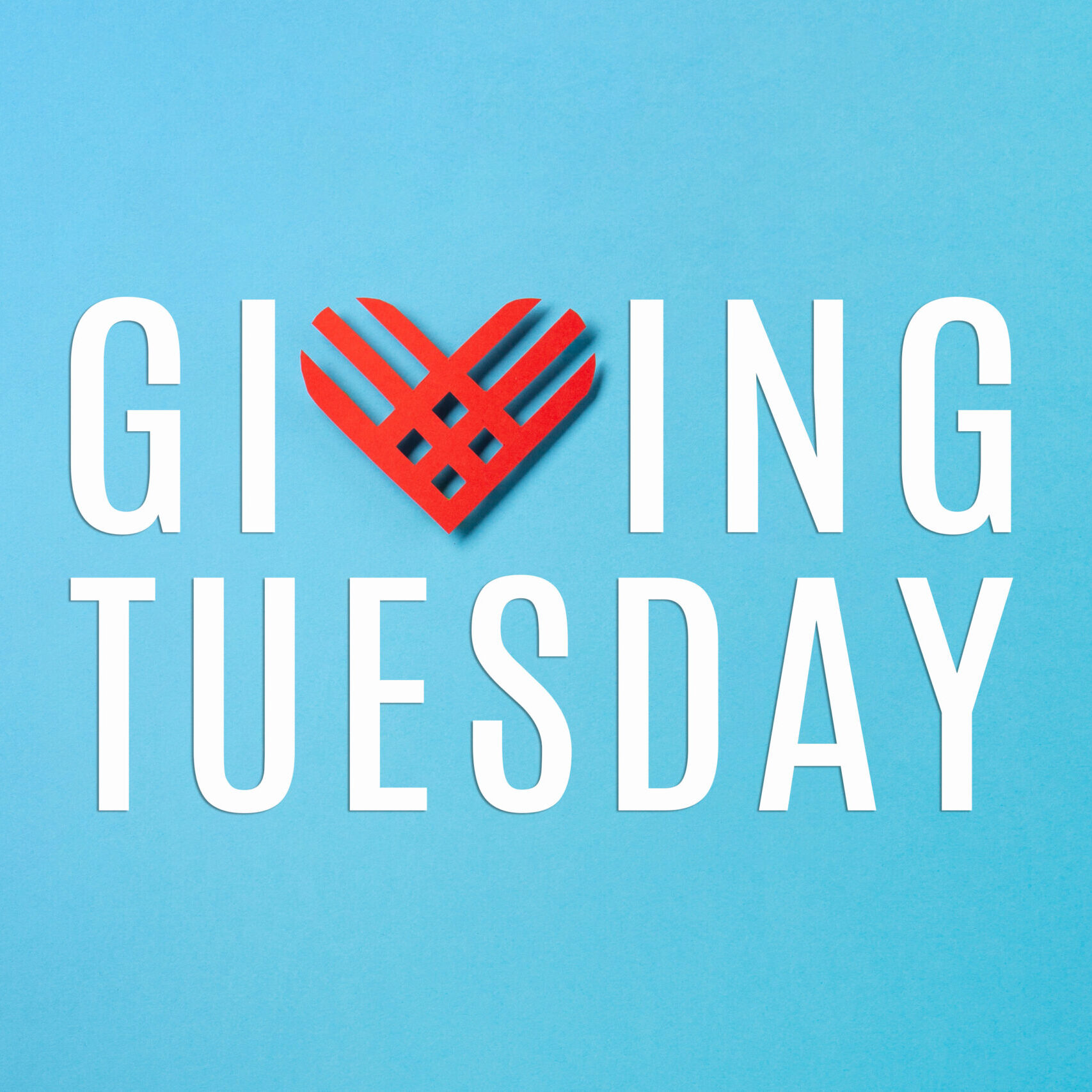 Giving Tuesday, global day of charitable giving after Black Friday shopping day. Charity, give help, donations support concept. Red paper heart on blue paper background. Top view, copy space, flat lay.