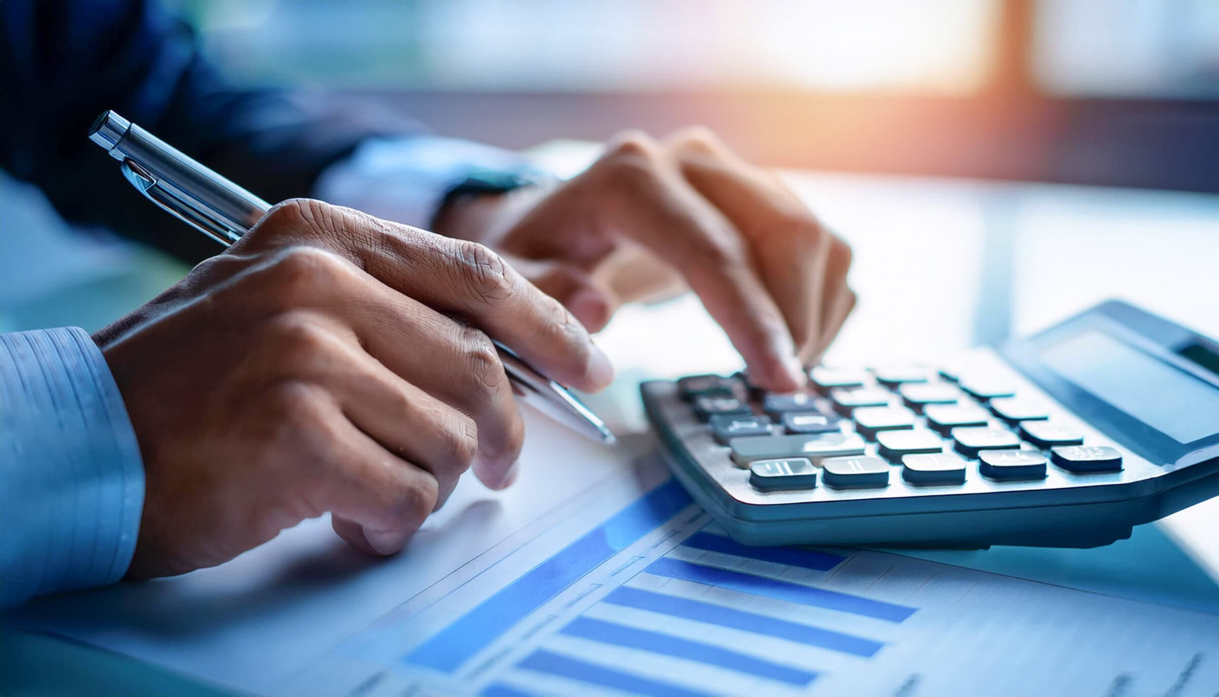 Close-up de unas manos preparando un presupuesto con calculadora y boligrafo concepto de economía y ahorro familiar y trabajo