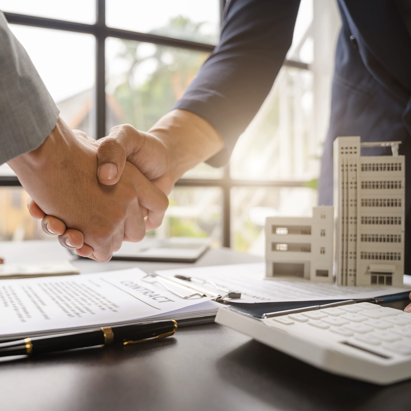 Close up shake hands, Considering buying a home, investing in real estate. Broker signs a sales agreement. agent, lease agreement, successful deal.