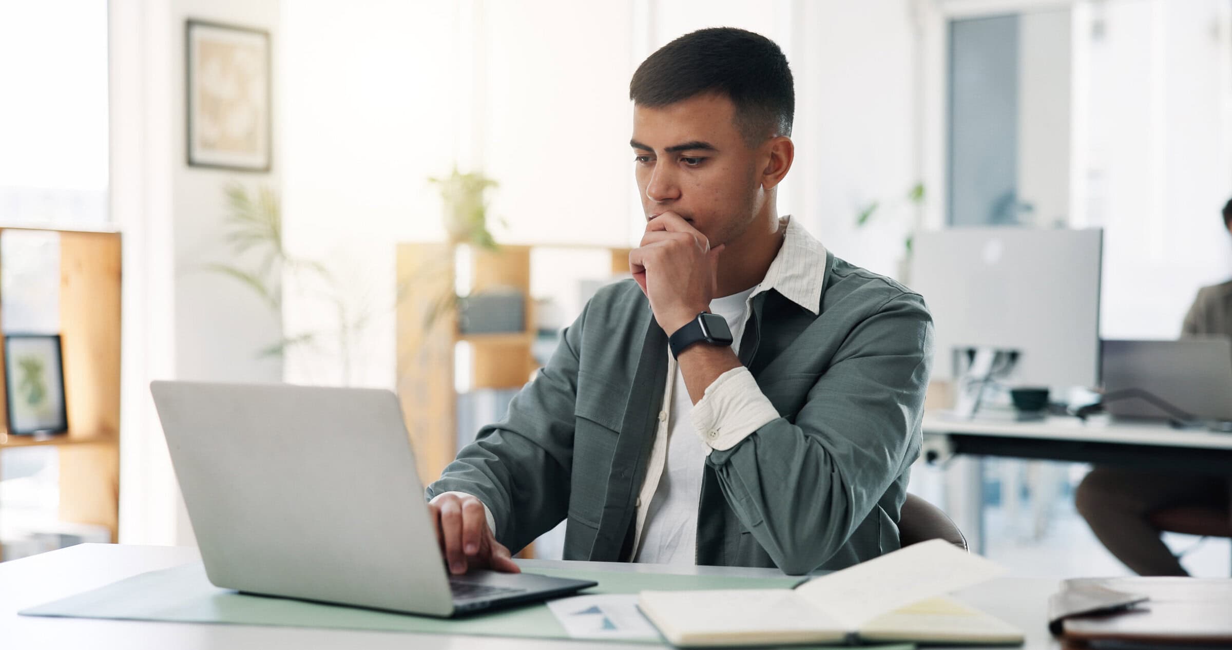 Businessman, laptop or thinking with documents for business idea, planning or strategy in office. Thoughtful, man or employee with computer for schedule, brainstorming or decision making in workplace.
